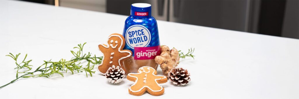 Gingerbread cookies displayed with a bottle of minced ginger and fresh ginger root on a kitchen counter