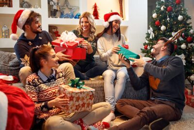 Friends celebrating the holidays with gifts and laughter in a festive living room