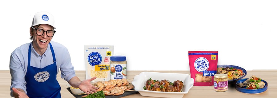 Happy chef showcasing Spice World products with prepared dishes on a kitchen counter