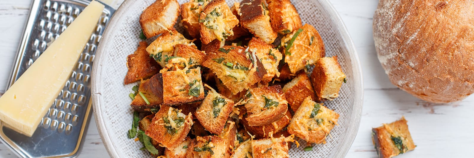 Homemade croutons with fresh herbs and grated cheese for salad toppings.