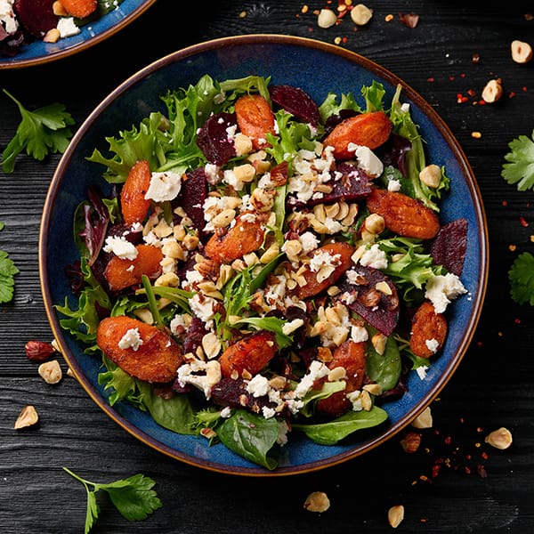 Healthy summer salad with roasted beets, goat cheese, nuts and mixed greens.