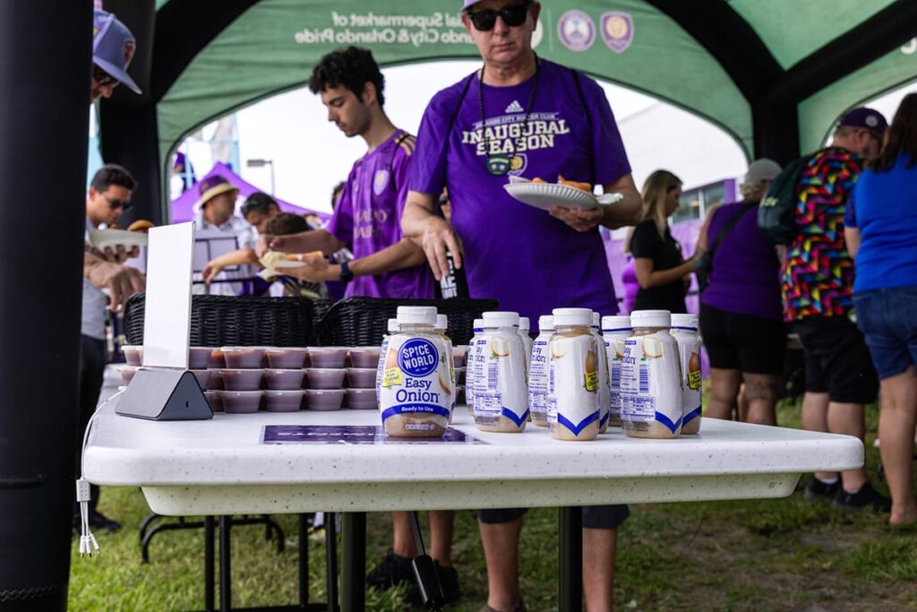 People serving and collecting food at an outdoor community event