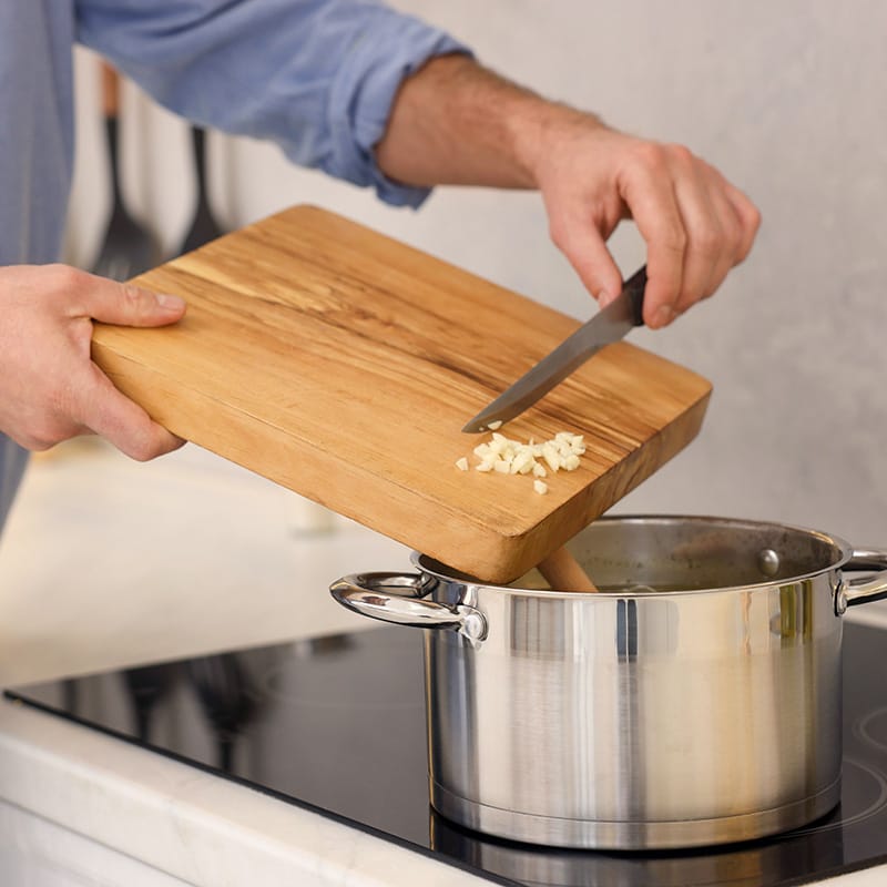 Assortment of colorful fruits, spices, seeds, and herbs arranged in small wooden bowls on a table.