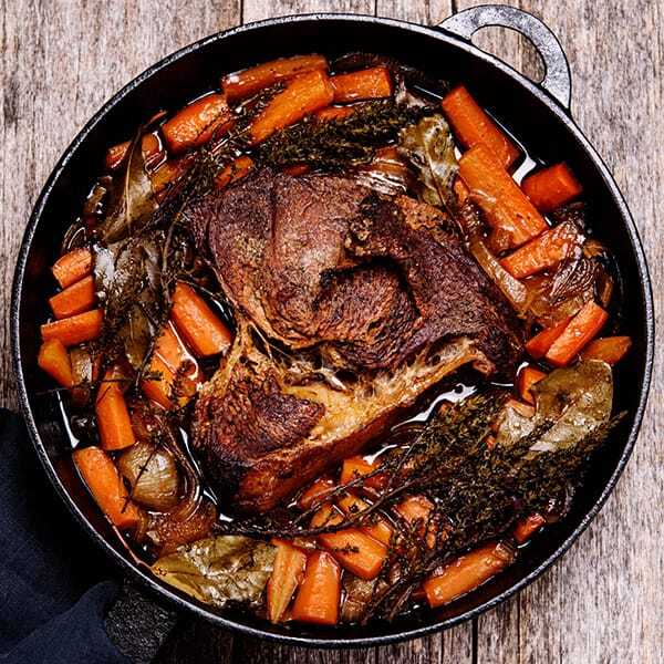 Roasted meat with carrots in a skillet, exemplifying a hearty meal