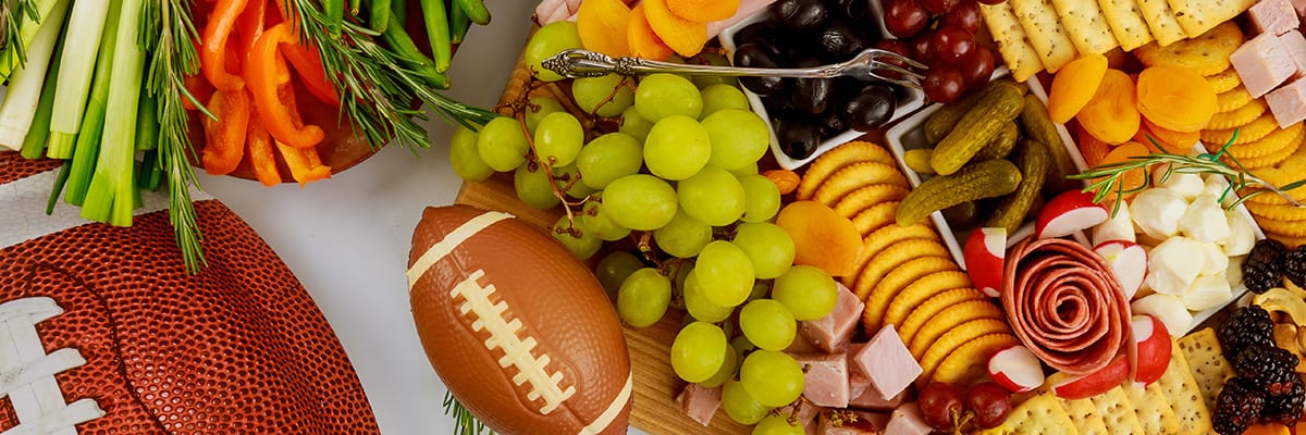 A vibrant charcuterie board featuring a variety of fruits, meats, cheeses, and snacks, perfect for gatherings