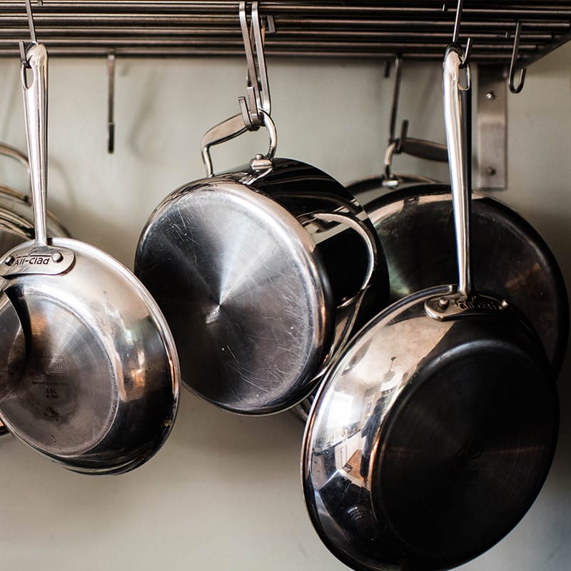 Hanging stainless steel pots and pans ready for cooking delicious meals in a well-equipped kitchen