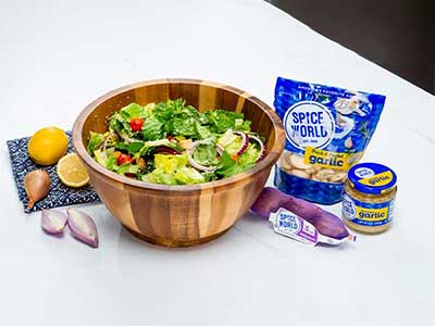 Fresh salad ingredients with garlic products, lemon, and shallots for flavorful cooking