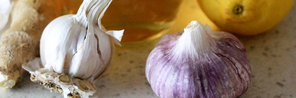 Ingredients for flavorful cooking: garlic, ginger, and fresh lemons on a kitchen countertop