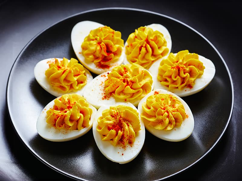 Plate of delicious stuffed deviled eggs, garnished with paprika, perfect for appetizers or gatherings