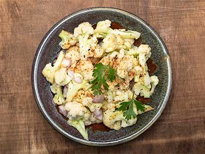 Plate of seasoned cauliflower with herbs, showcasing a delicious vegetable dish perfect for healthy meals