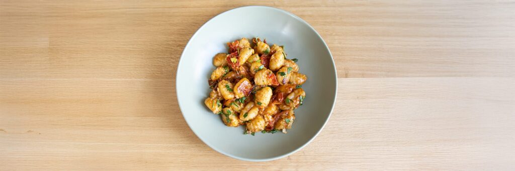 Plate of gnocchi tossed with flavorful ingredients, ready to be enjoyed as a delicious meal
