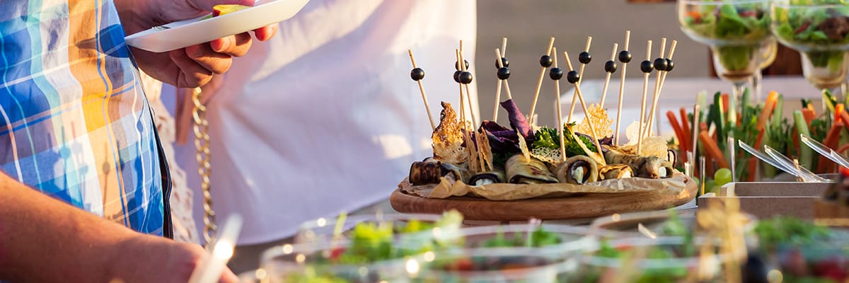 Friends enjoying a variety of delicious appetizers and fresh salads at a vibrant outdoor gathering