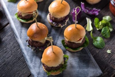 Assortment of delicious mini burgers on a slate board, perfect for parties and gatherings