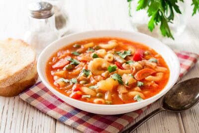 Bowl of hearty vegetable soup served with bread, perfect for a comforting meal