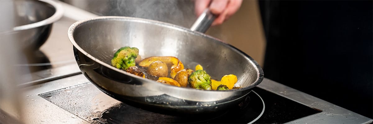 Chef sautéing colorful vegetables in a pan, creating a delicious and visually appealing dish
