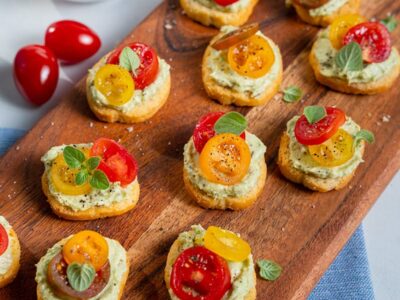 Delicious bite-sized appetizers topped with fresh tomatoes and herbs on a wooden serving board. Perfect for gatherings