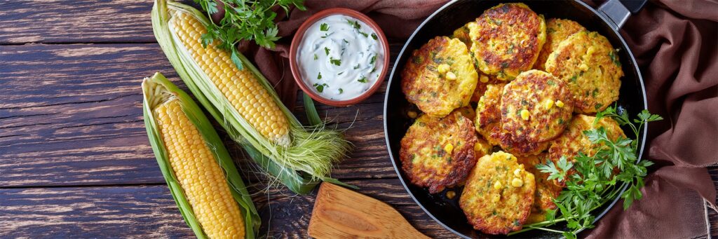 Delicious corn fritters served with fresh herbs and a creamy dip, perfect for a delightful meal or snack